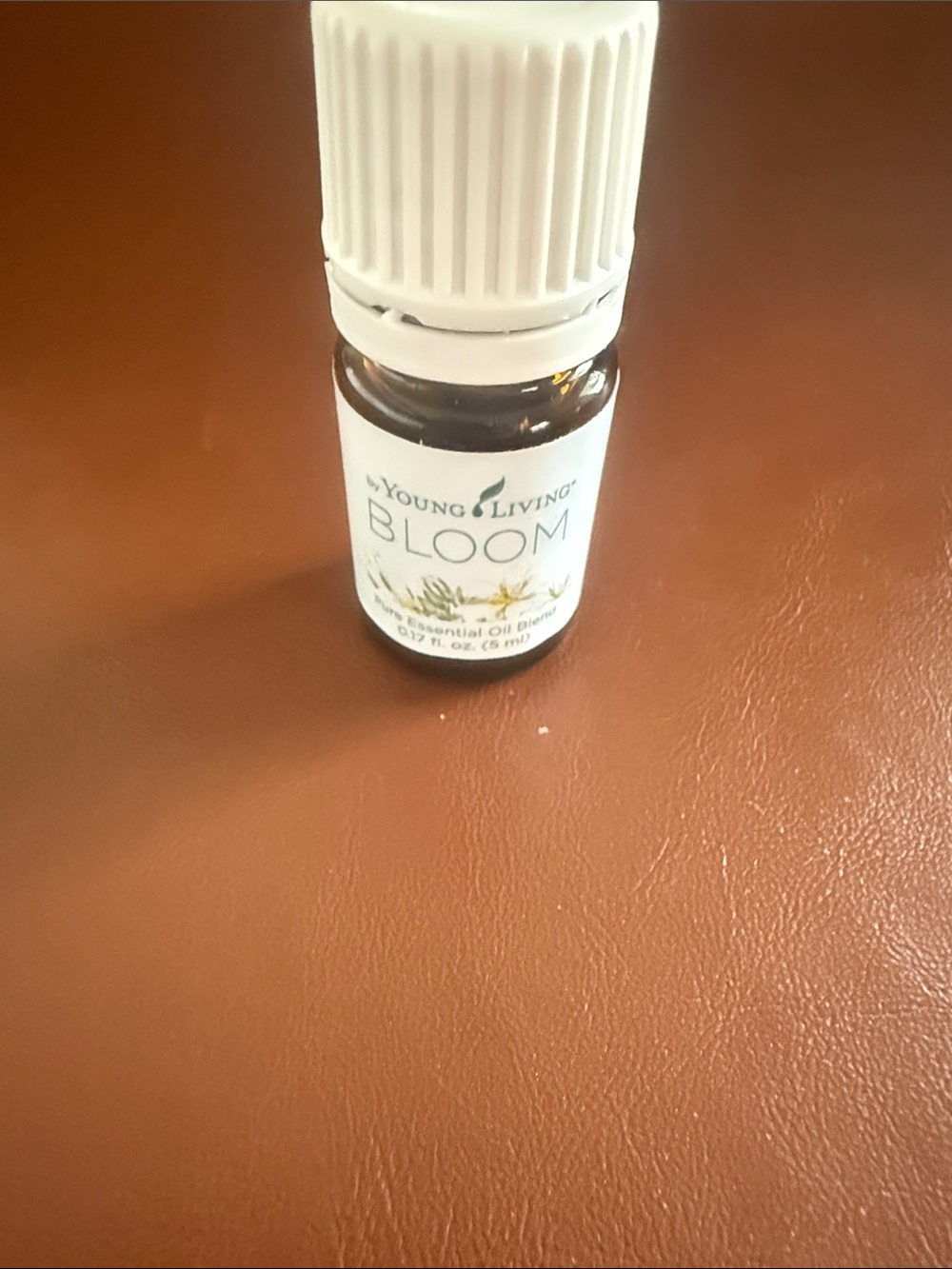 Young Living Bloom Essential Oil Bottle - White Cap on Brown Surface